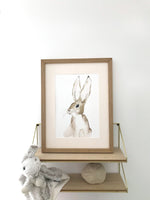 Cadre avec affiche aquarelle d'un lapin avec des grandes oreilles pour décorer la chambre d'un bébé.